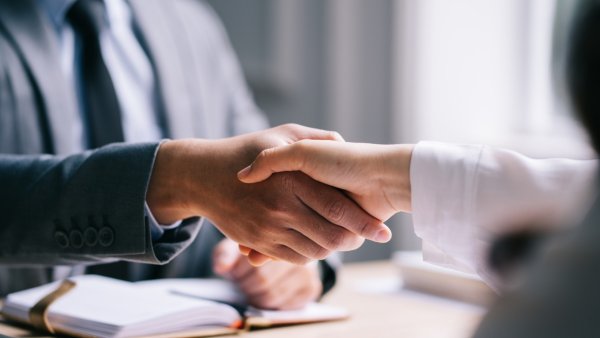 Image of two business people sharing hands. 