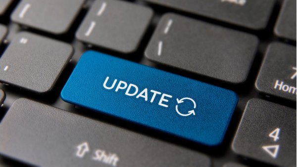 Image of a person at a laptop screen with an updating screen.  